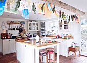 Child's drawings hang from ceiling beam in open plan kitchen of Devonshire farmhouse UK