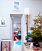 Christmas tree and lamp with view through doorway to bedroom of London family home England UK