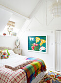 Butterfly artwork in bedroom with checked blankets Oxfordshire farmhouse England UK