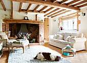 Dog sleeping on rug in living room with recessed brick fireplace in Surrey farmhouse England UK