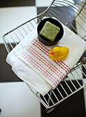 Soap dish and rubber duck on wire mesh chair in bathroom of Margate family home Kent England UK