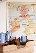 Wall map of UK with blue metal coffee pots on wooden sideboard in schoolhouse conversion Brittany France