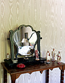 Figurines with vintage mirror on wooden dressing table in traditional country house Welsh borders UK
