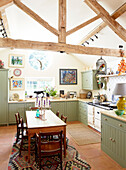 Balkenküche mit Holztisch und Stühlen in einem Landhaus in Oxfordshire, England, UK