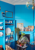 Collection of religious icons and chinaware on bright blue shelving in Auckland dining room North Island New Zealand