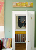 Gestreiftes Kissen mit Kunstwerk und Blick durch eine Tür in einem Haus in Notting Hill, West London UK