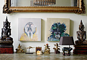 Buddhist ornaments and artwork canvas above sideboard in Notting Hill home West London UK