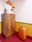 Oranger Koffer und Leuchten mit Vintage-Garderobe in Notting Hill, West London, UK