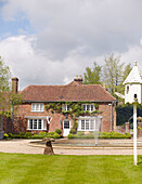 Water fountain and brick facade of detached Buckinghamshire home UK