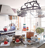 Pan rack above kitchen island in sunlit Brittany guesthouse France