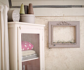 Glass cabinet and empty picture frame in Brittany farmhouse France