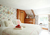 Perlenkette und Buch auf einem Doppelbett in einem Cottage in Devonshire UK