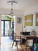 Chrome pendant light above desk and chair with typewriter in Kent home England UK