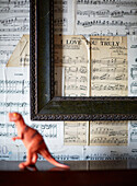 Empty picture frame mounted over musical scores with dinosaur in Kent home England UK
