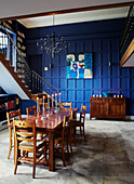 Wooden dining table and chairs in blue panelled Northumbrian manor house England UK