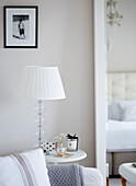 Lamp and cut flowers with scented candle on side table in York townhouse England UK