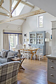 Open plan living space in modernised Northumbrian country house with double height beamed ceiling UK