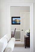 Antique wooden travelling chest and radiator below framed photograph in living room of Northumbrian country house UK