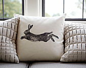 Leaping hare cushion on window seat in modernised Northumbrian country house UK