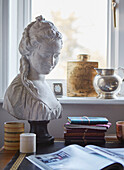 Female bust and diaries with open magazine on desk at window in Speldhurst home Kent England UK