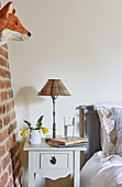 Fox head on exposed brick wall above bedside table in Grade II listed Tudor bastle Northumberland UK