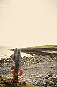 Schal und Rettungsring an einem Betonpfosten mit Blick auf das Meer von einem Kieselstrand in der Grafschaft Sligo Connacht Irland
