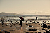 Jungen tragen Bodyboards ins Meer an der Küsten der Grafschaft Sligo in Connacht, Irland
