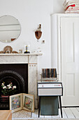 Circular mirror above marble fireplace with record player and records in Country Durham bedroom, North East England