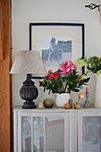 Cut flowers and lamp with black and white framed photo in Kent home, England, UK