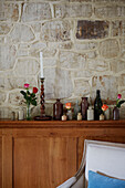 Collection of vases and exposed stone wall in Kent home, North East England, UK