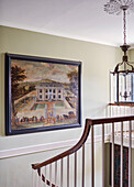 Framed oil painting and polished wooden banister in staircase of Capheaton Hall, Northumberland, UK