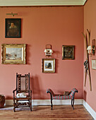 Gilt framed artwork and carved wooden chair in corner of Capheaton Hall, Northumberland, UK