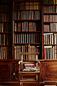 Wooden chair in front of library in Capheaton Hall, Northumberland, UK