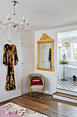 Oriental dressing gown with wicker chair and gilt-framed mirror at doorway to ensuite in Yorkshire home, England, UK
