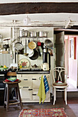 Pots and pans on rack above oven in Powys cottage kitchen, Wales, UK