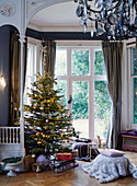 Sledge under lit Christmas tree in window of East Grinstead home, West Sussex, UK