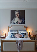 Lit candles at bedside below oil painting in East Grinstead home, West Sussex, UK