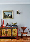 Vasen und Bücher mit poliertem Holzstuhl und lackierter Anrichte in einem Regency-Haus in den Cotswolds, England, UK