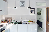 Blätter auf einem Abtropfbrett mit einer Schale Birnen in der Küche einer Edwardianischen Wohnung in London, UK