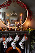 Beleuchtete Kerzen und Weihnachtsstrümpfe mit konvexem Spiegel in einem Londoner Haus, UK