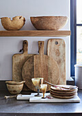 Collection of wooden chopping boards and bowls in renovated Cotswolds cottage, UK