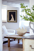 Portrait of a Parisian lady and large seashell in living room of renovated Cotswolds cottage, UK