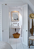 Mirror above basin in ensuite bathroom renovated Cotswolds cottage, UK