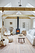 Wood burning stove in living room of Grade II listed West Sussex barn conversion, UK