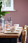 Crockery and glassware on wooden table in Tunbridge Wells home, Kent, UK