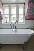 White freestanding bath below window in Berkshire cottage, England, UK