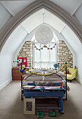 Large pendant shade above bed in attic of Woodstock church conversion Oxfordshire, UK
