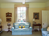 Light blue checked sofa at window in Syresham home, Northamptonshire, UK