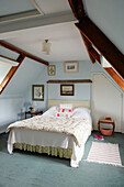 Light blue attic conversion with quilted bed cover in Syresham home, Northamptonshire, UK