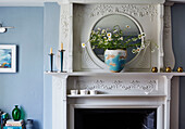 Cut daisies on decorative mantlepiece in Deddington home, Oxfordshire, UK